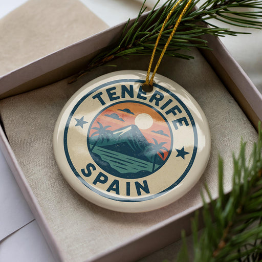 A circular ornament with the text "Tenerife Spain" on it, surrounded by a pine branch and pine needles.
