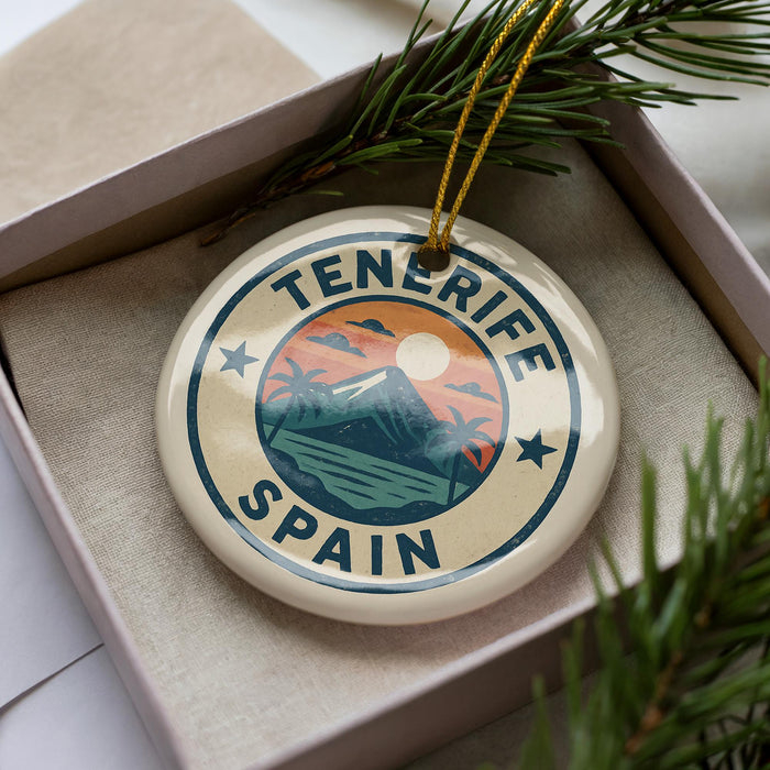 A circular ornament with the text "Tenerife Spain" on it, surrounded by a pine branch and pine needles.