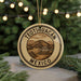 A circular ornament with the text "TEOTIHUACAN MEXICO" printed on it, surrounded by pine branches and twinkling lights.