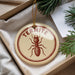 A round ornament with the word "TERMITE" printed on it, featuring a detailed illustration of a termite.