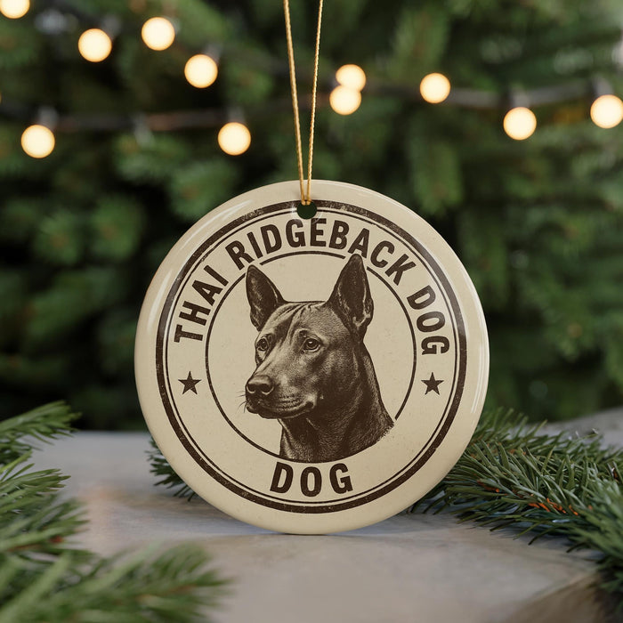 A circular ornament featuring a dog's head and the text "THAI RIDGEBACK DOG" is displayed in front of a blurred Christmas tree.