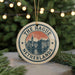 A circular ornament with the text "THE HAGUE NETHERLANDS" and an illustration of a cityscape, hanging from a string.