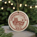 A circular ornament with the text "THIRUVANANTHAPURAM INDIA" printed on it, featuring an illustration of a temple and palm trees.