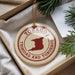 A circular ornament with the text "TOBAGO TRINIDAD AND TOBAGO" printed on it, surrounded by pine branches.