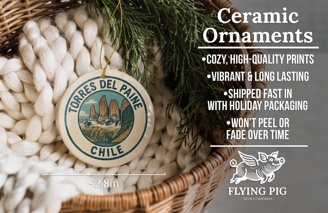 Ceramic ornaments, specifically a round ornament with a mountain landscape design, are displayed in a woven basket.
