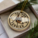 A circular ornament with the text "TOY FOX TERRIER" printed on it, featuring a dog's head image.