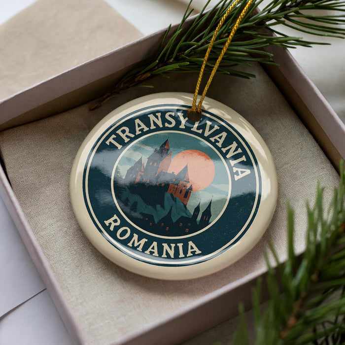 A circular ornament with the text "TRANSYLVANIA ROMANIA" and a castle illustration, placed in a box with pine branches.