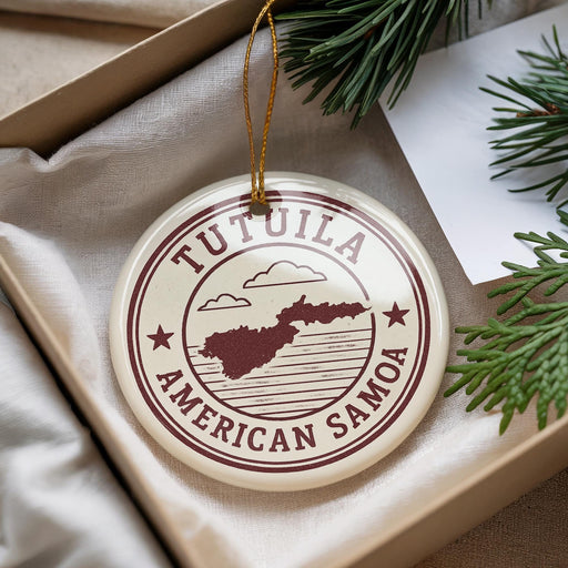 A circular ornament with the text "TUTUILA AMERICAN SAMOA" printed on it, surrounded by pine branches and a white paper.