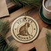A round ornament featuring a monkey sitting on a wooden surface, with the text "VERVET MONKEY" printed on it.