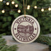 A round ornament with the text "VICTORIA SEYCHELLES" and an illustration of a town or village, hanging from a string.