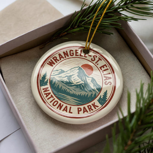 A circular ornament with the text "WRANGELAND ST ELIAS NATIONAL PARK" printed on it, surrounded by pine branches.