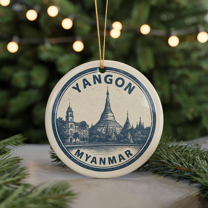 A circular ornament with a drawing of a temple and the text "YANGON MYANMAR" on it, hanging from a string.