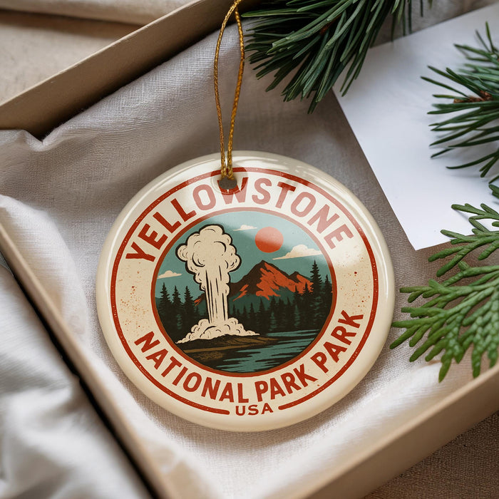 A decorative ornament with the text "Yellowstone National Park" and an illustration of a mountain range, steam, and pine trees.