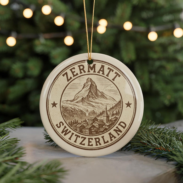 A circular ornament with the text "ZERMATT SWITZERLAND" and an illustration of a mountain and village, hanging from a string.