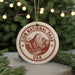 A circular ornament with the text "ZION NATIONAL PARK USA" and an illustration of a mountain range, hanging from a string.