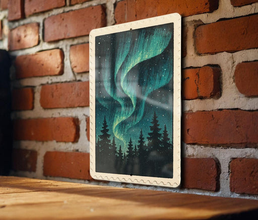 A framed image of a night sky with a stunning display of the Aurora Borealis, or Northern Lights, is hanging on a brick wall.