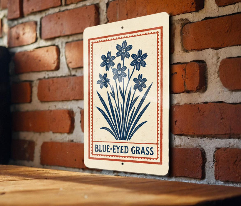 A sign with a blue flower design is hanging on a brick wall.