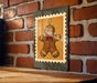 A framed image of a gingerbread man is hanging on a brick wall.