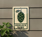a sign with a pine cone design and the text "HEMLOCK CONE" on it, mounted on a wall.