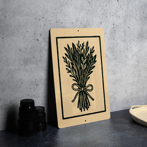 a beige sign with a black illustration of a bunch of leaves and a bow on it, placed on a gray countertop next to a stack of black camera lenses.