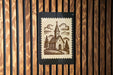 A church illustration on a postage stamp is displayed on a wooden wall.
