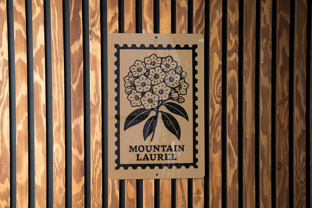 A wooden wall with a sign featuring a floral design and the text "MOUNTAIN LAUREL".