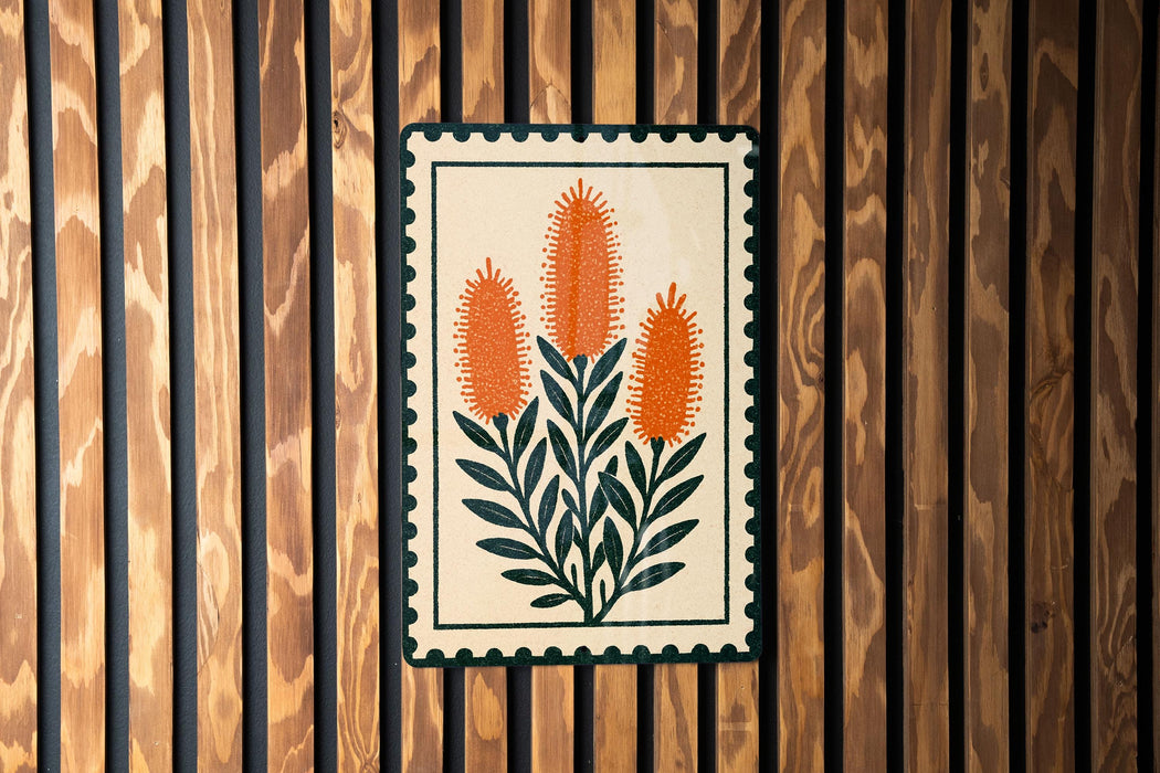 a decorative sign with a floral design, hanging on a wooden wall.