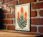 a decorative sign with a floral design, hanging on a brick wall.