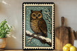 A framed image of an owl perched on a branch, with a snowy background, is displayed on a shelf next to a wooden cutting board and a potted plant.