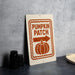 a sign for a pumpkin patch, with a pumpkin and an arrow pointing to the right.