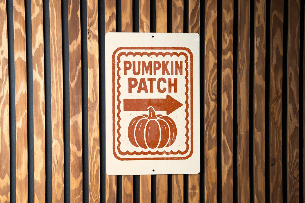 A sign on a wooden wall that reads "PUMPKIN PATCH" with an arrow pointing to the right.