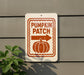 a sign for a pumpkin patch with an orange pumpkin and a directional arrow.