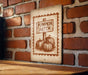 a sign that reads "Pumpkin Patch" with three pumpkins depicted on it, mounted on a brick wall.