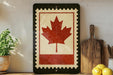 a kitchen counter with a framed Canadian flag, a wooden cutting board, and some lemons.