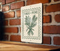 a sign with the text "SAGE + PINE" and an illustration of a plant, mounted on a brick wall.