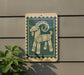 a green and white sign with a stylized goat design on it, mounted on a wall.