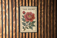 A framed image of a red peony flower is displayed on a wooden wall.