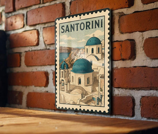 A vintage-style metal sign with a picture of Santorini's iconic buildings, mounted on a brick wall.