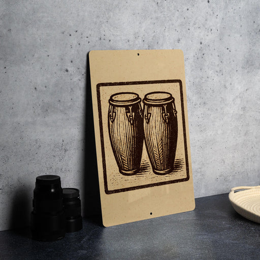 a brown sign with a black and white illustration of two drums, placed on a gray countertop next to a stack of black camera lenses.