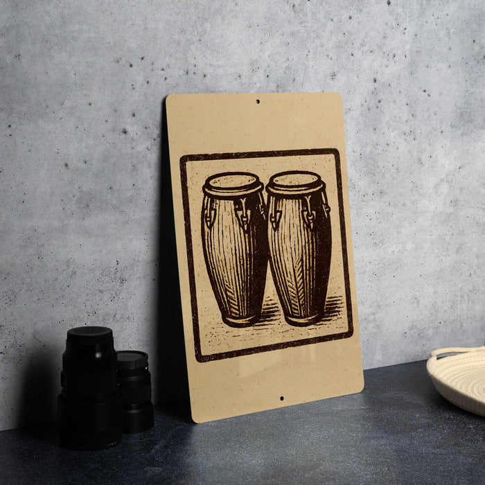 a brown sign with a black and white illustration of two drums, placed on a gray countertop next to a stack of black camera lenses.