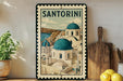 A framed illustration of Santorini, a Greek island, is displayed on a shelf next to a wooden cutting board and some potted plants.