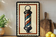 a barber pole with a striped design, placed on a shelf next to a wooden cutting board and some lemons.