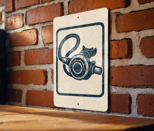a sign with a drawing of a scuba diving equipment, such as a diving mask or snorkel, mounted on a brick wall.