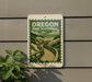 A sign for Oregon Dune Boardwalk is displayed on a wall, featuring a scenic illustration of a wooden boardwalk winding through a mountainous landscape.