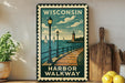 A vintage-style metal sign depicting a harbor walkway in Wisconsin, with sailboats and a lighthouse in the background.