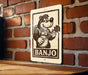 A sign featuring a cartoon image of a bear playing a banjo, with the word "BANJO" written below the image.