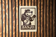 A sign featuring a cartoon image of a bear playing a banjo.