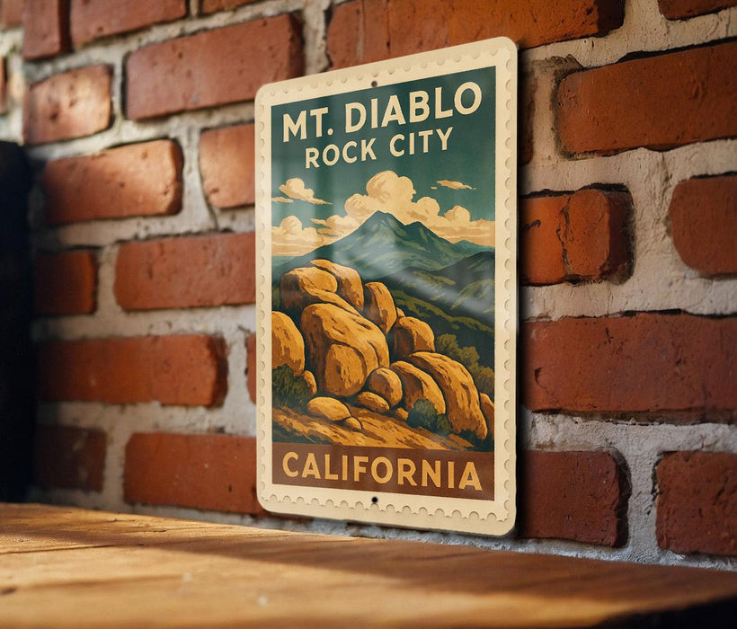 A vintage-style metal sign with the text "MT. DIABLO ROCK CITY" and "CALIFORNIA" printed on it, hanging on a brick wall.