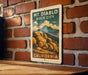 A vintage-style metal sign with the text "MT. DIABLO ROCK CITY" and "CALIFORNIA" printed on it, hanging on a brick wall.