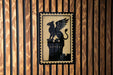 A black and gold emblem featuring a winged lion is displayed on a wooden wall.